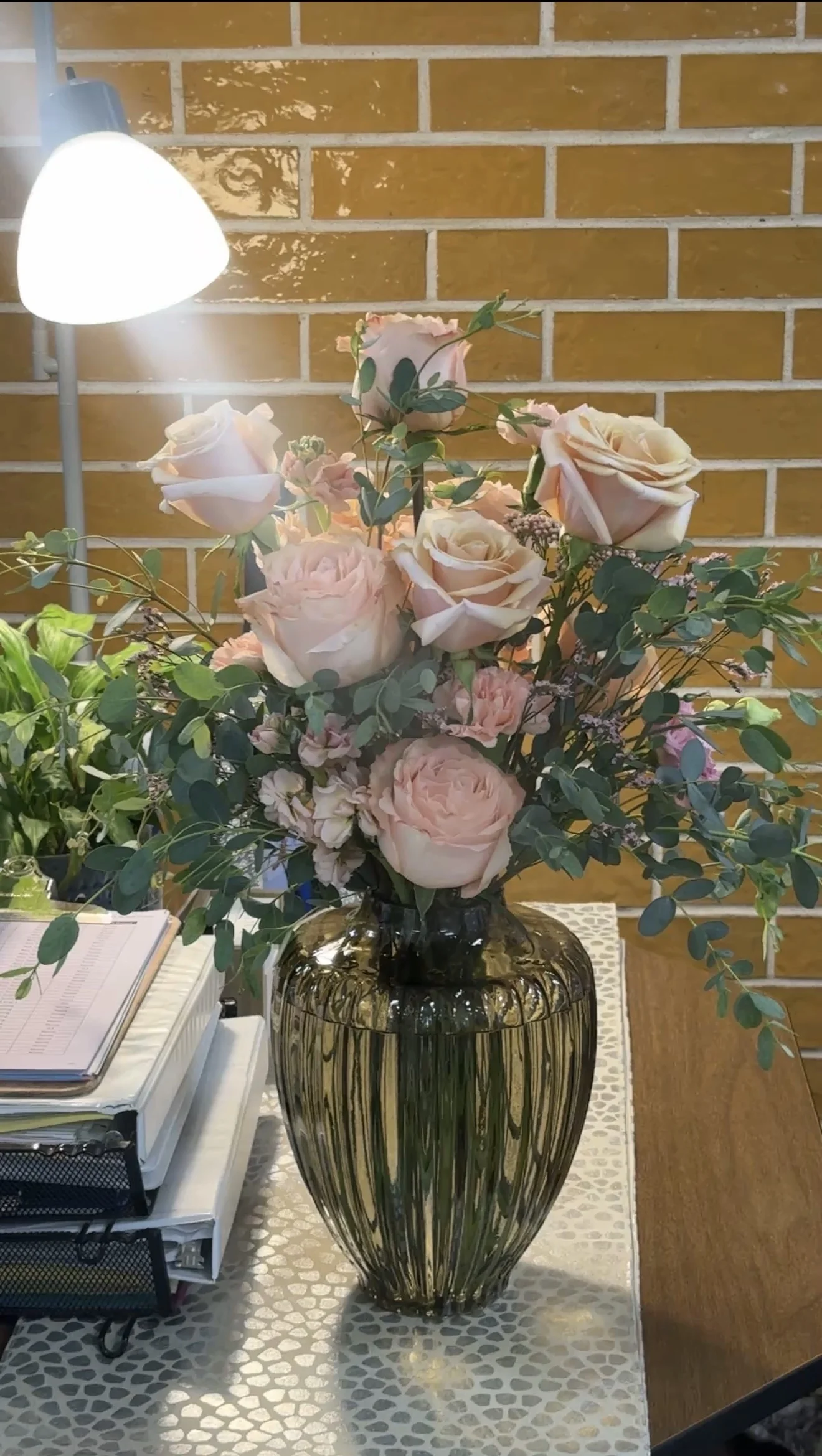 Blush roses and eucalyptus in a ribbed glass vase