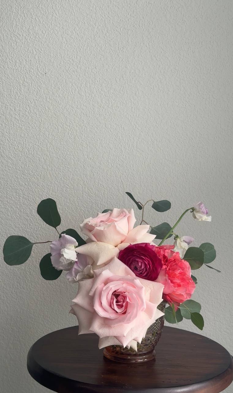 Low arrangement with pink and raspberry blooms
